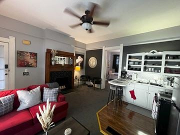 Fort Wayne apartment for rent - a living room with a red couch and a kitchen and a ceiling fan