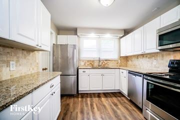 Columbus house for rent - a kitchen with white cabinets and stainless steel appliances