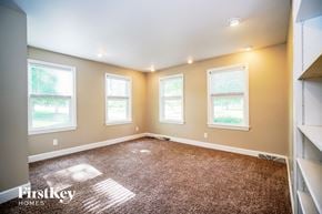 Columbus house for rent - a bedroom with a carpeted floor and three windows