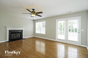 Winston-Salem house for rent - A room with a fireplace and a ceiling fan.