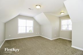 Winston-Salem house for rent - A spacious room with a carpeted floor and two windows.