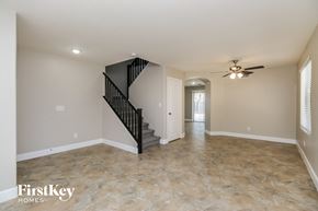San Tan Valley house for rent - A spacious room with a staircase and a ceiling fan.