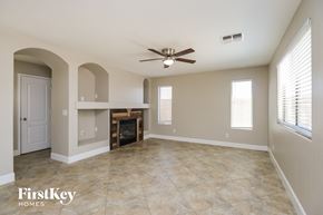 San Tan Valley house for rent - A spacious living room with a fireplace and a ceiling fan.