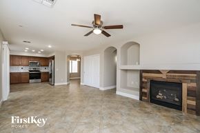 San Tan Valley house for rent - A spacious living room with a fireplace and a ceiling fan.