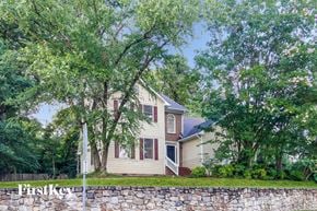 Greensboro house for rent - a house with a stone wall and trees