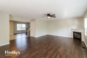 Milford house for rent - an empty living room with a fireplace and a ceiling fan