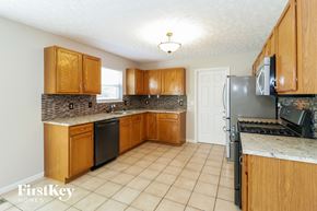 Milford house for rent - a kitchen with wooden cabinets and a stove and refrigerator