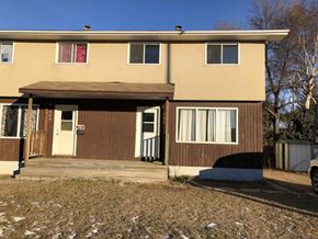 Prince Albert house for rent - the front of a tan house with a wooden porch