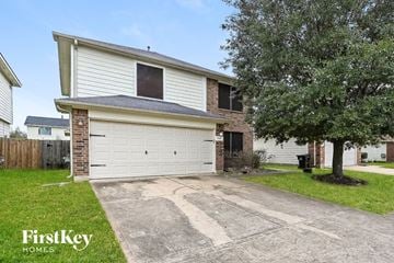 Humble house for rent - a white garage door in front of a brick house