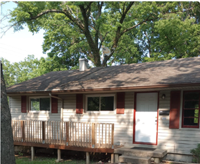 Cincinnati house for rent - A house with a white door and red window frames is surrounded by trees.