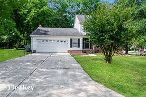 Charlotte house for rent - A white house with a black roof and a grey garage door.