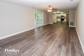 Charlotte house for rent - A spacious room with wooden flooring and a ceiling fan.