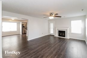 Loveland house for rent - an empty living room with a ceiling fan and a fireplace