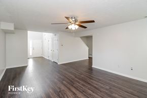 Loveland house for rent - an empty living room with a ceiling fan and white walls