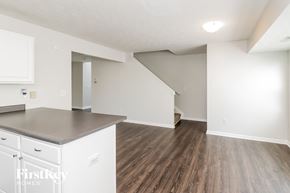 Loveland house for rent - a renovated kitchen and living room with white cabinets and wood flooring