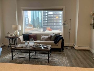 Edmonton house for rent - a living room with a large window and a couch and a table