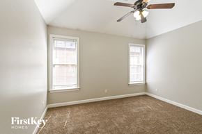 Memphis house for rent - a bedroom with a ceiling fan and two windows