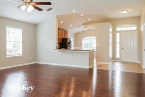 St Augustine house for rent - an empty living room with a kitchen and a ceiling fan