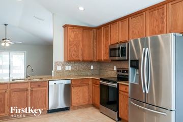 St Augustine house for rent - a kitchen with wooden cabinets and stainless steel appliances