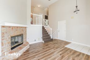 Shawnee house for rent - A living room with a fireplace and a staircase.