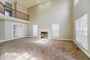 Columbus house for rent - an empty living room with a fireplace and a balcony