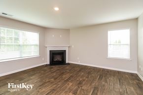 Dallas house for rent - A room with a fireplace and wooden floors.