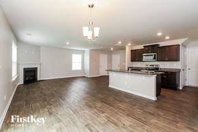 Dallas house for rent - A spacious kitchen and living room with wooden floors and a fireplace.