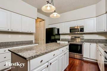 Saint Charles house for rent - a kitchen with white cabinets and granite counter tops