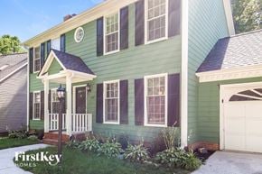 Greensboro house for rent - a green house with a white porch and a white garage door