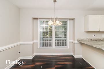 Greensboro house for rent - a kitchen with a window and white cabinets and a table