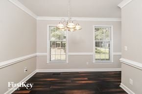 Greensboro house for rent - a empty dining room with a chandelier and two windows