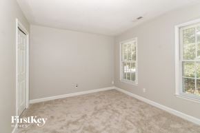 Greensboro house for rent - a bedroom with a carpeted floor and two windows