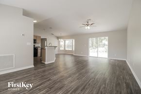 Cocoa house for rent - A spacious living room with wood flooring and a ceiling fan.