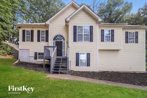 Cartersville house for rent - A beige house with a black door and windows.