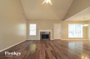 Cartersville house for rent - A spacious room with wooden floors and a fireplace.