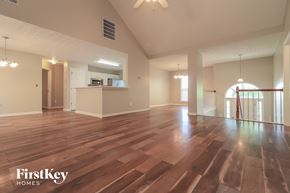 Cartersville house for rent - A spacious room with wooden flooring and a staircase on the right side.