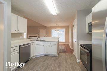 Cartersville house for rent - A kitchen with white cabinets and a wooden floor.