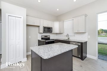 Palm Bay house for rent - A kitchen with a granite countertop and white cabinets.