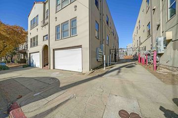 Berkeley apartment for rent - A street view of a residential area with buildings on both sides and a closed garage door.
