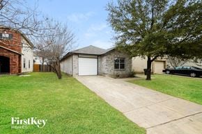 Sanantonio house for rent - A house with a garage and a tree in front of it.