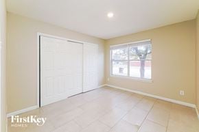 Sanantonio house for rent - A room with a white door and a window with a view of a tree and a building outside.