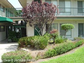 Westminister apartment for rent - a yard with a tree and plants in front of a building