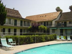 Westminister apartment for rent - a large swimming pool in front of a hotel with chairs