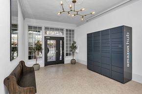 San Francisco apartment for rent - A room with a brown chair and a black Amazon Hub locker.