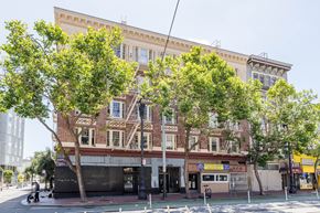 San Francisco apartment for rent - A large building with a balcony on the second floor is surrounded by trees.