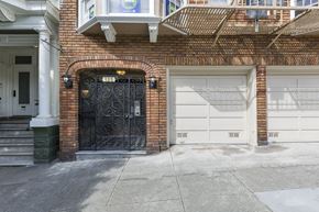 San Francisco apartment for rent - A black wrought iron gate is on the left side of a brick building.