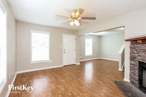 Jacksonville house for rent - A spacious room with a fireplace and a ceiling fan.