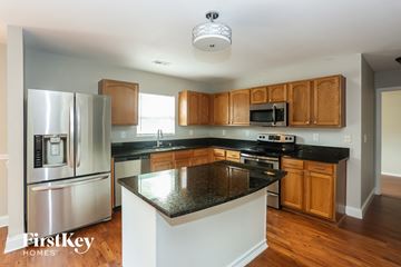 Charlotte house for rent - A kitchen with a black granite counter top and wooden cabinets.
