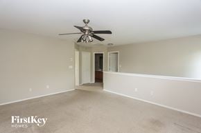 Charlotte house for rent - A spacious room with a ceiling fan and two doors.