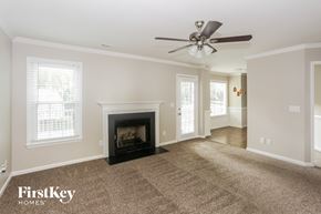 Charlotte house for rent - A living room with a fireplace and a ceiling fan.